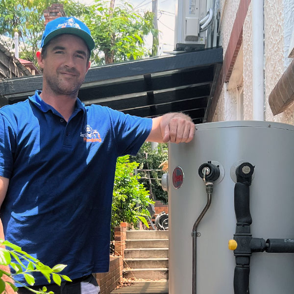 Plumber leaning on Rheem tank hot water heater